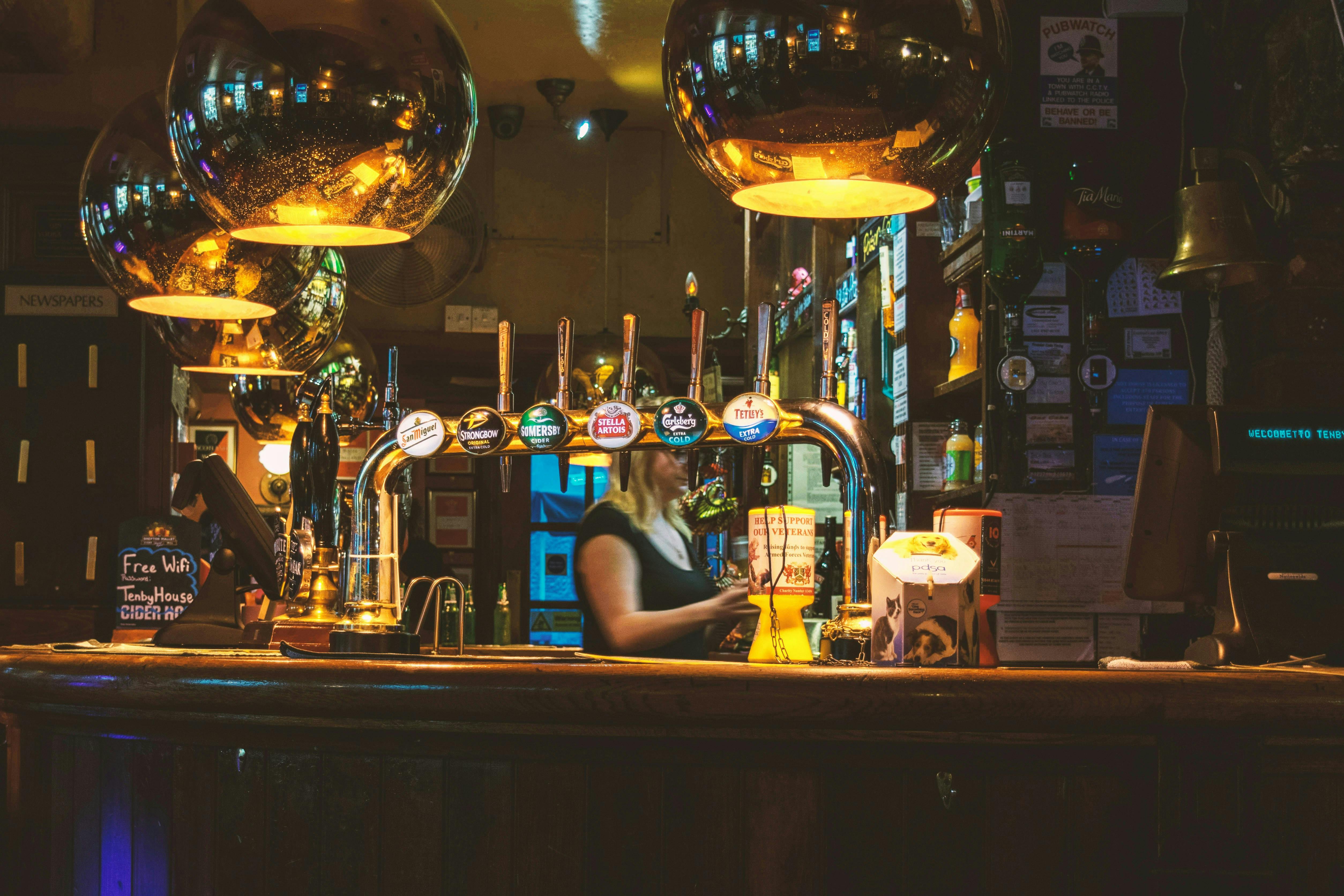 A bartender at a British pub with mood lighting